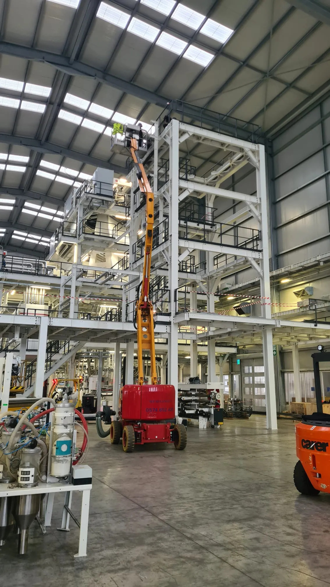 Cherry picker reaching a high industrial steel structure