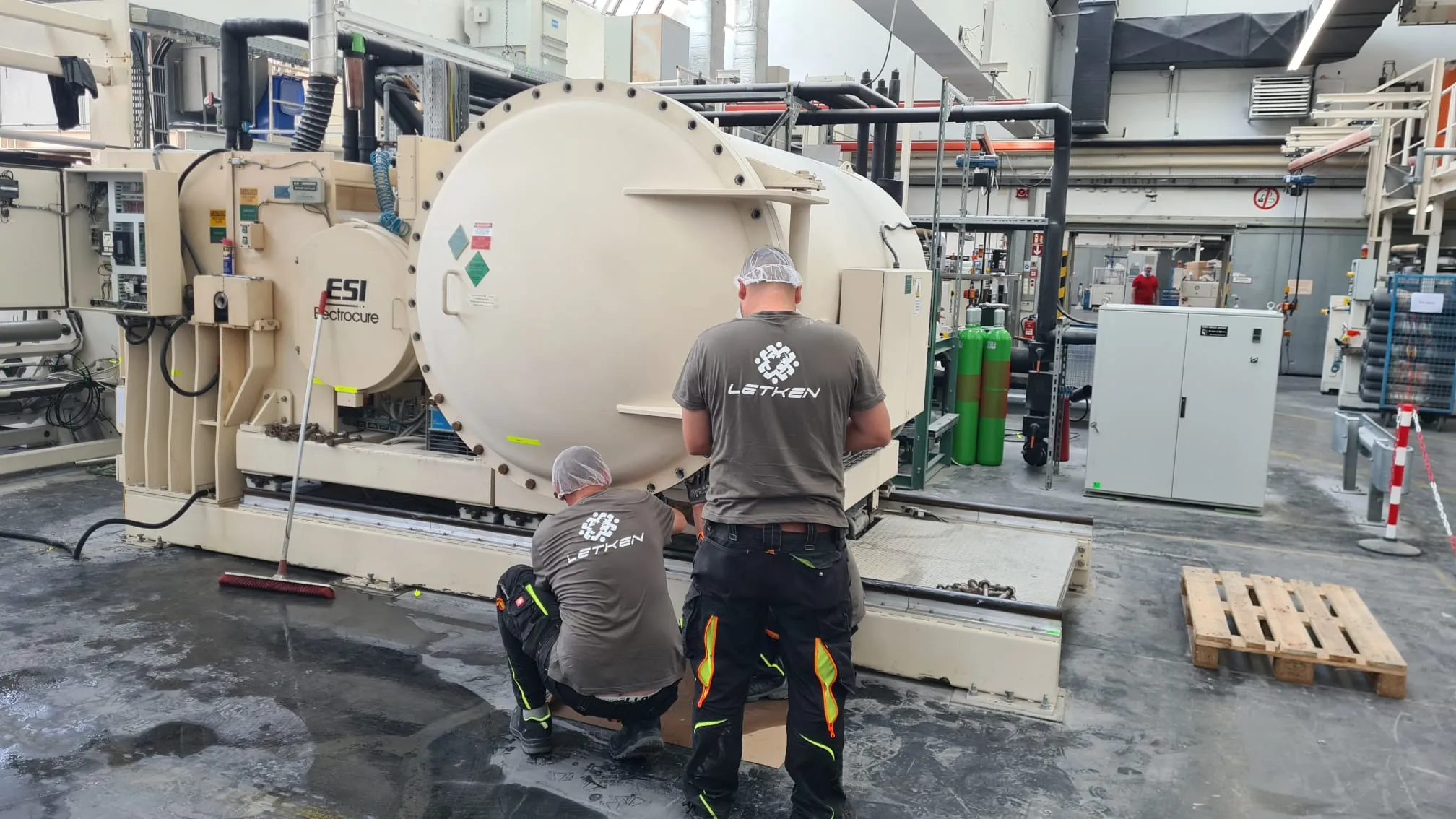 LETKEN technicians servicing an ESI Electrocure machine