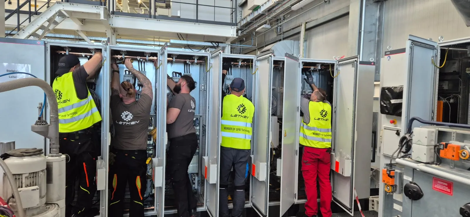 LETKEN technicians wiring a row of electrical cabinets