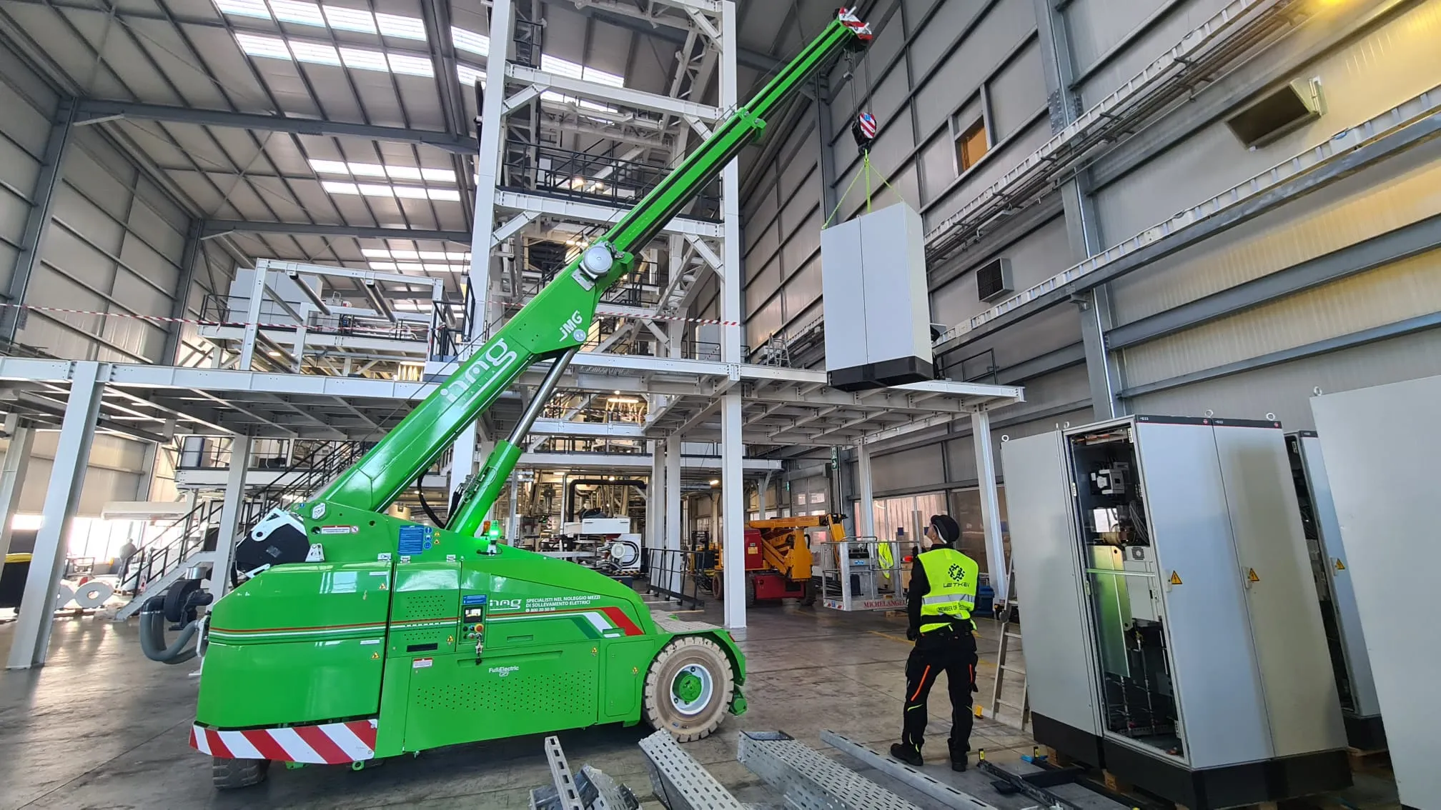 Indoor crane lifting an electrical control cabinet