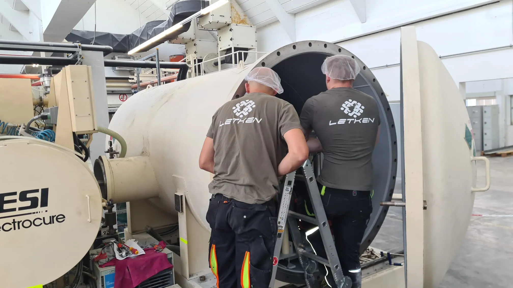 Technicians working inside an open industrial process machine