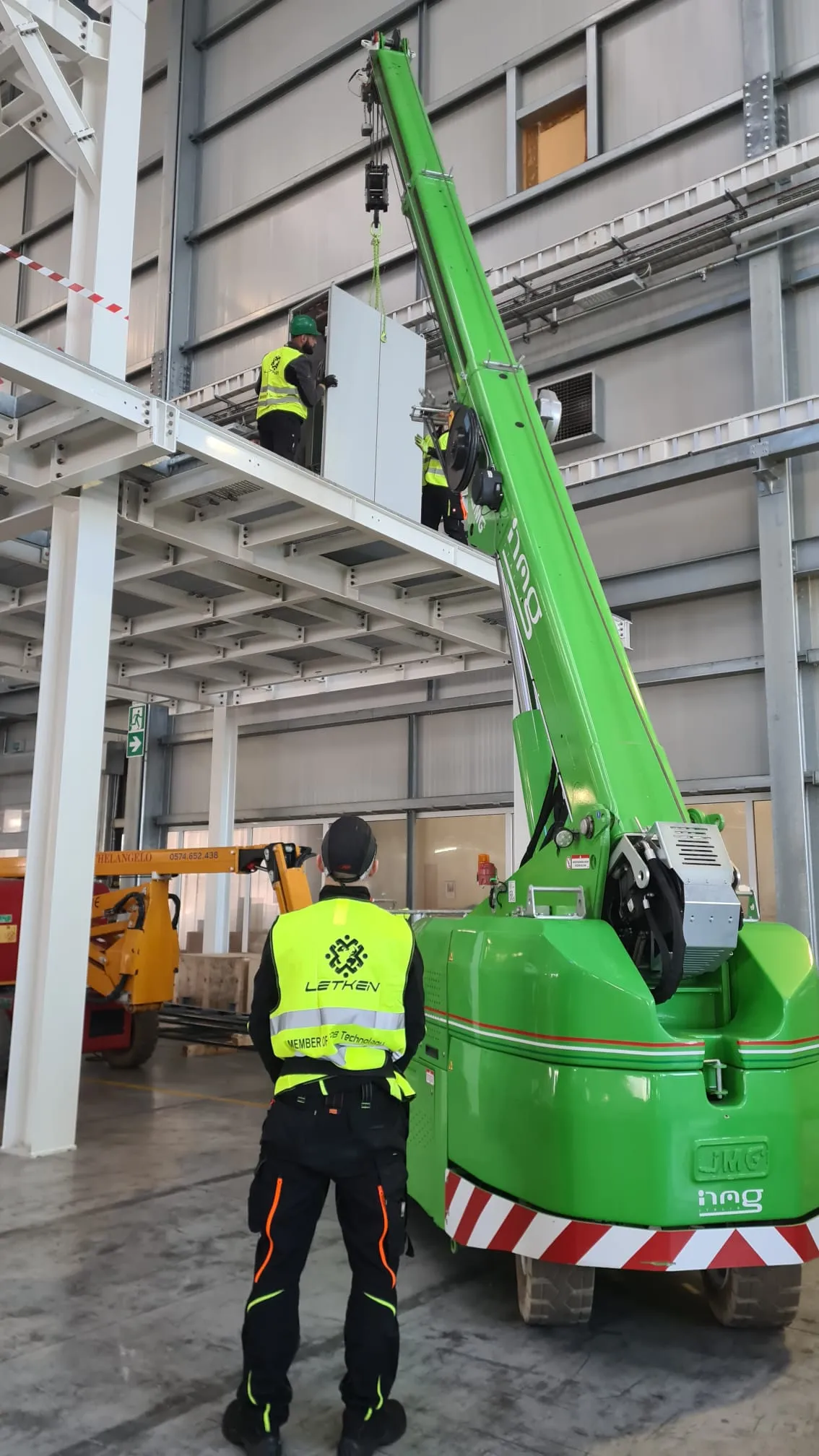 Crane placing a panel onto an elevated factory platform