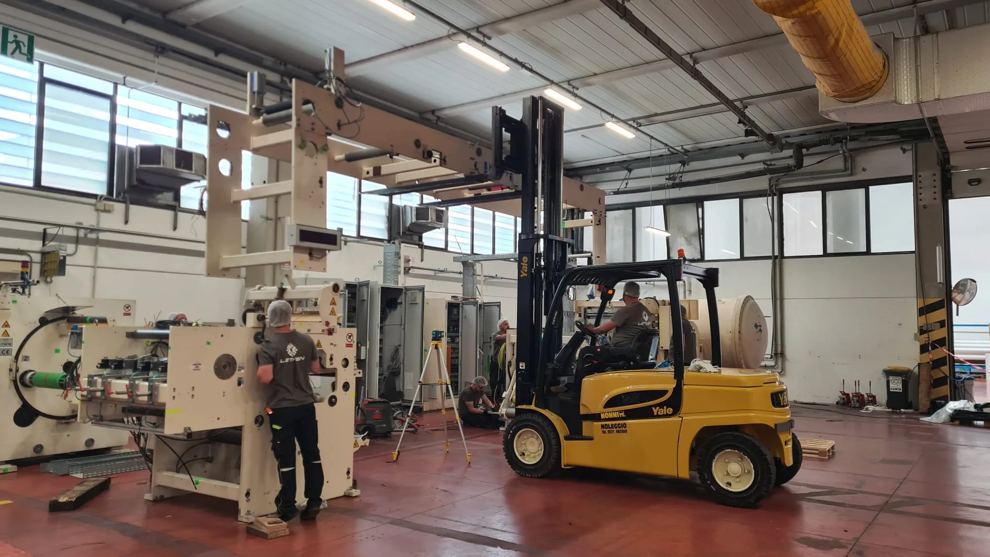 Forklift and laser level during precision machine assembly